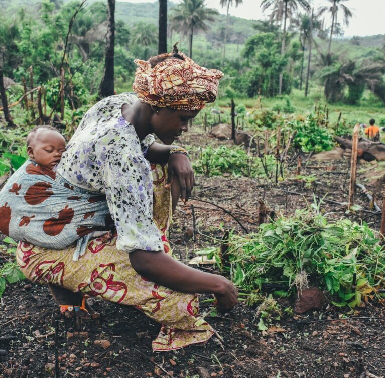women carrying baby in her back close-up photography